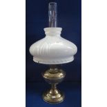 Brass oil lamp with fluted opaque shade and clear chimney.