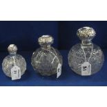 Three hobnail and similar cut glass globular scent bottles with repousse silver tops.