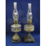 Two similar brass double burner oil lamps with glass reservoirs,