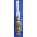 Cast metal oil lamp with relief decoration, double burner and chimney.