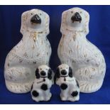 Pair of Staffordshire pottery white over-gilded seated Spaniels with painted features together with