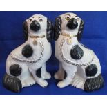 Pair of Staffordshire type black and white over-gilded seated Spaniels.