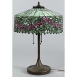 Patinated bronze table lamp, early 20th c., probably Handel, with a leaded mosaic glass shade,