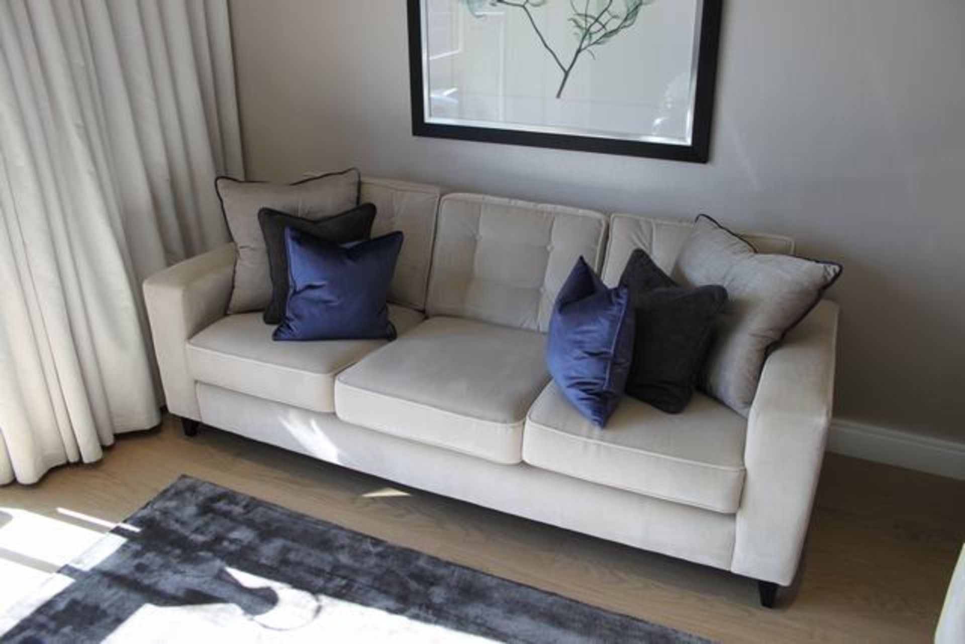 Contemporary upholstered three seater sofa, on solid wood frame with loose tufted back cushion rests