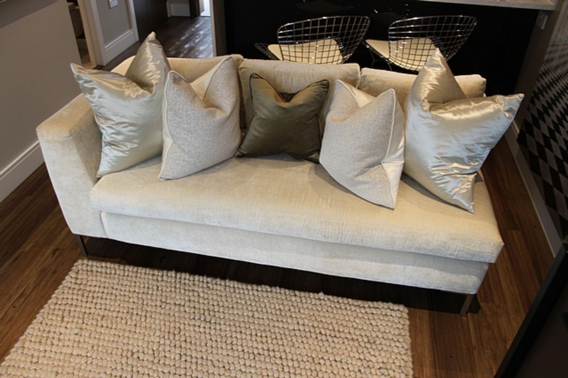 An upholstered cream sofa with one open end and one end with rolled armrest 1700mm x 860mm