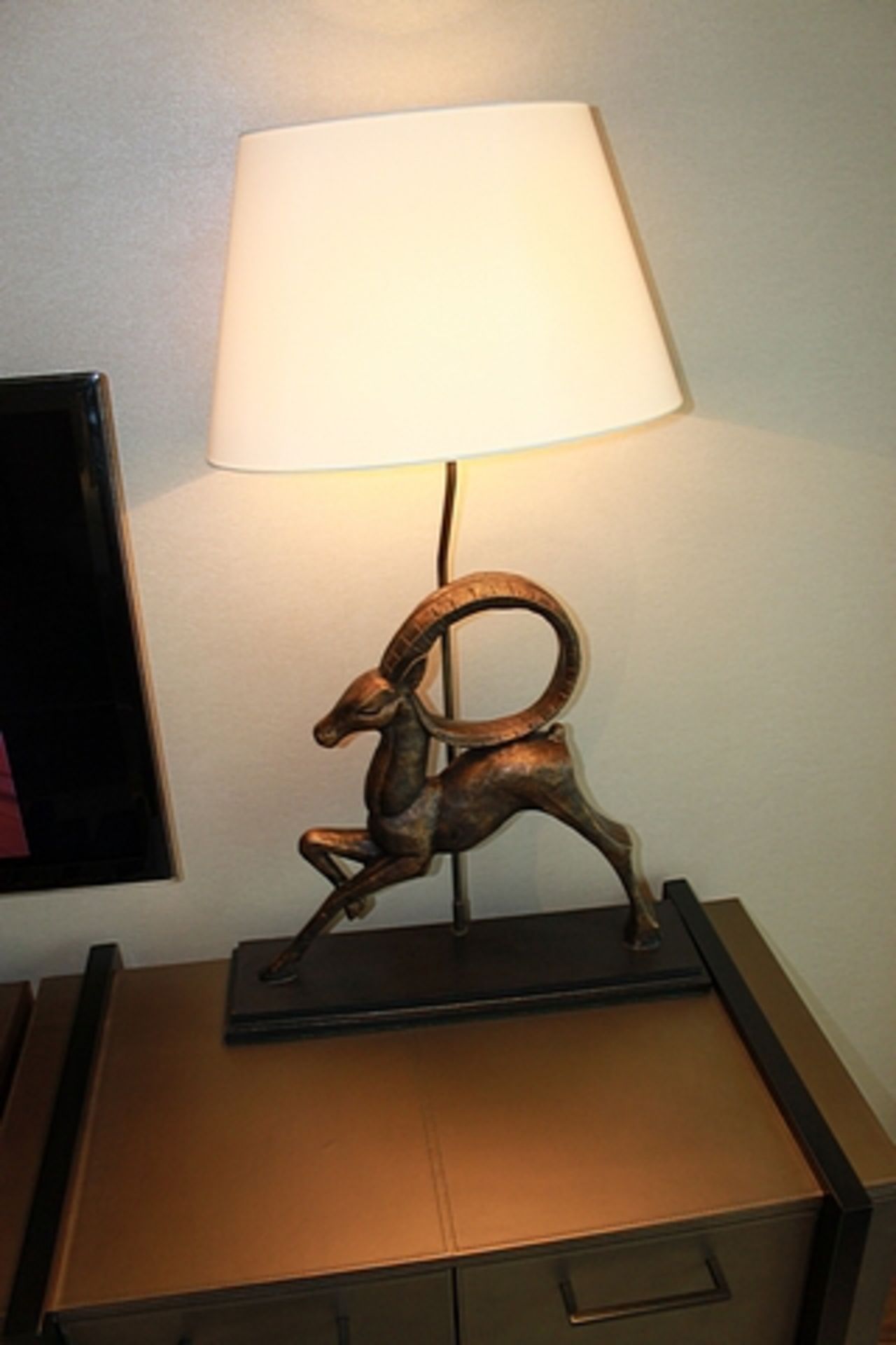 A table lamp the base features a mythical ram structure 910mm tall