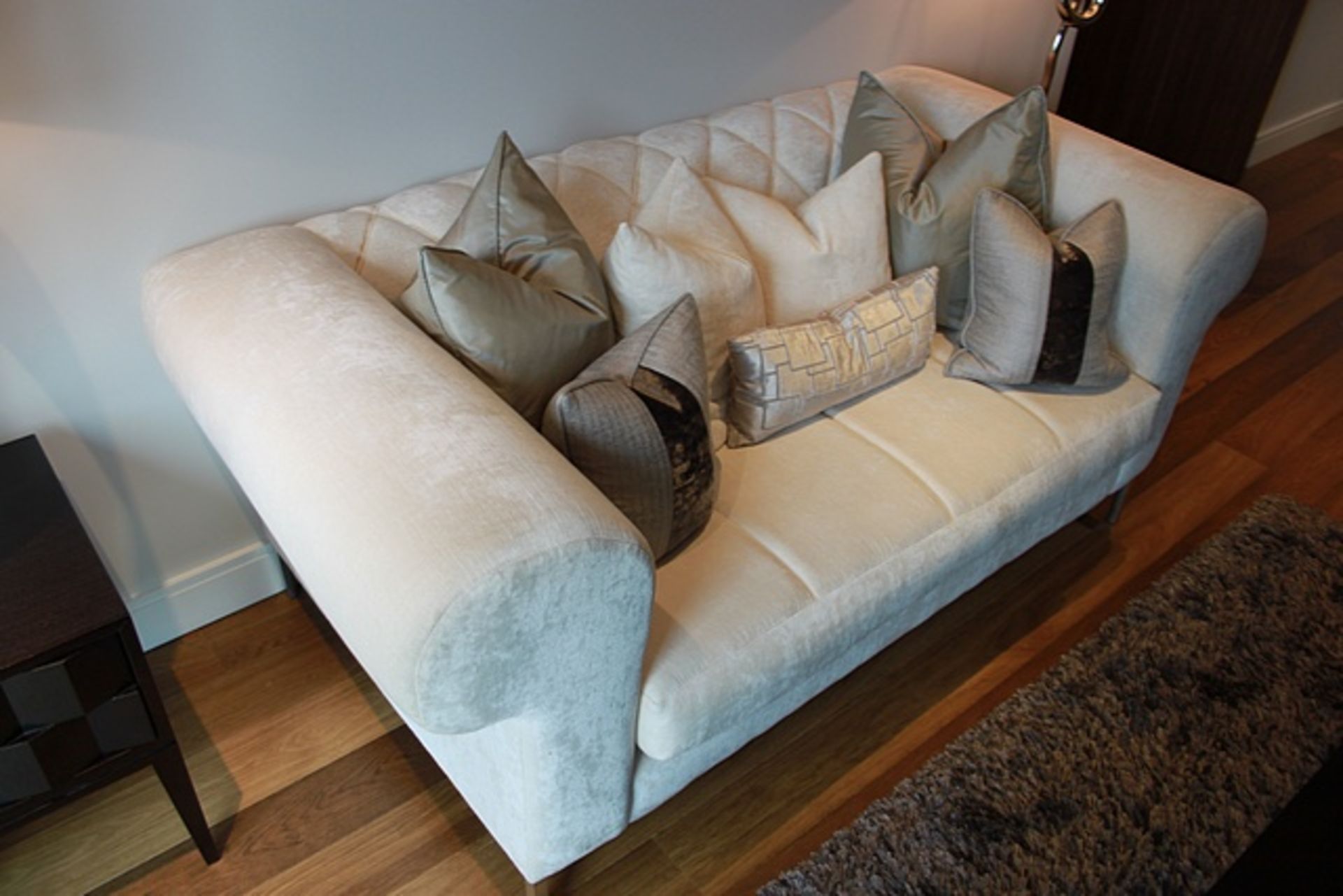 A cream white velveteen upholstered sofa with pattern back rest and soft cushion pads 1800mm x 920mm