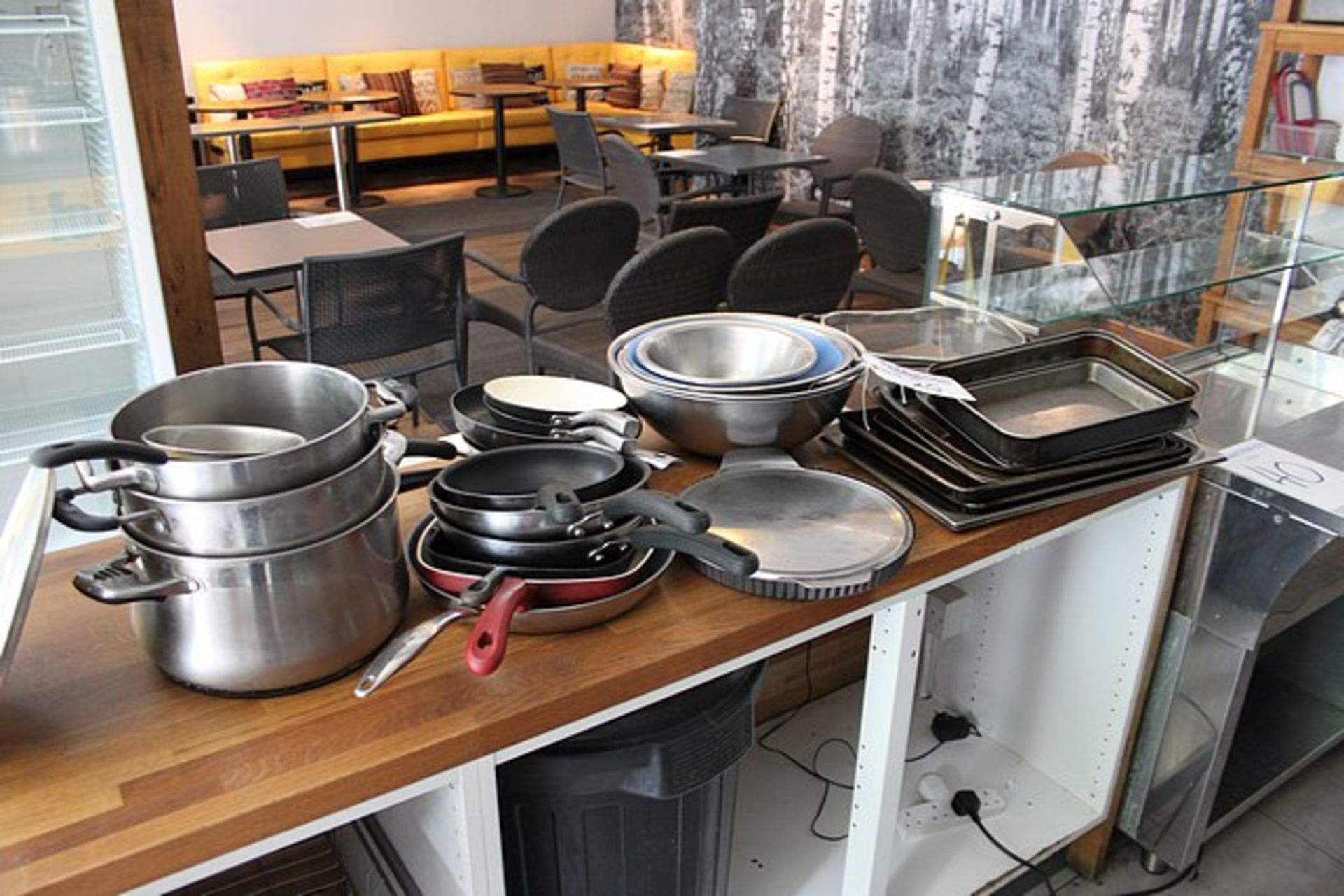 A quantity of frying pans, stainless saucepans, stainless steel mixing bowls and baking pans as