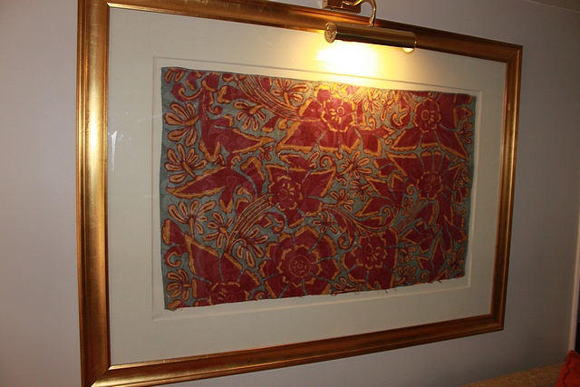 A framed textile fabric tapestry 1560mm x 1130mm complete with brass picture lamp