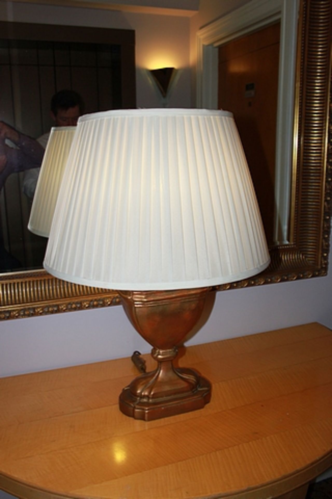 A gold painted table lamp in the form of a scroll urn with linen shade 750mm tall