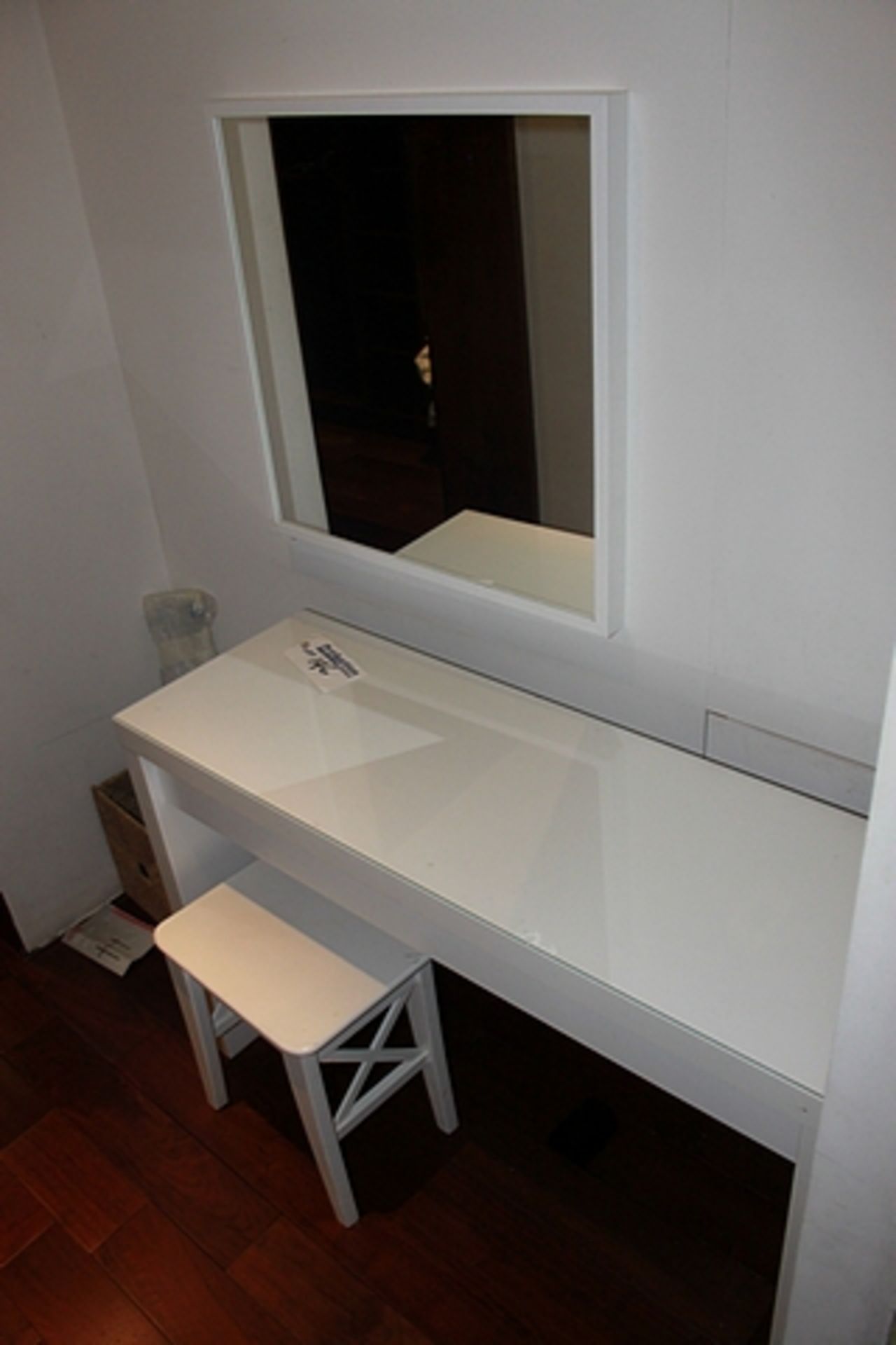 A dressing table, stool and wall mirror in laminate gloss white