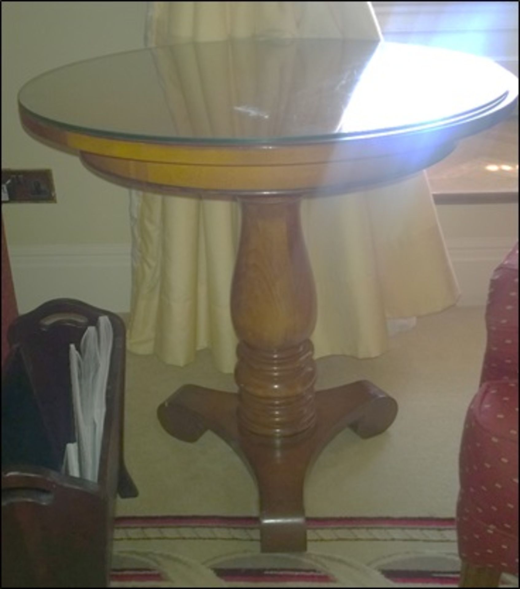 A light mahogany circular top occasional table on carved baluster pedestal mounted on tri-form