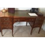 A Georgian style serpentine writing desk shaped inlay top above a central frieze drawer flanked by