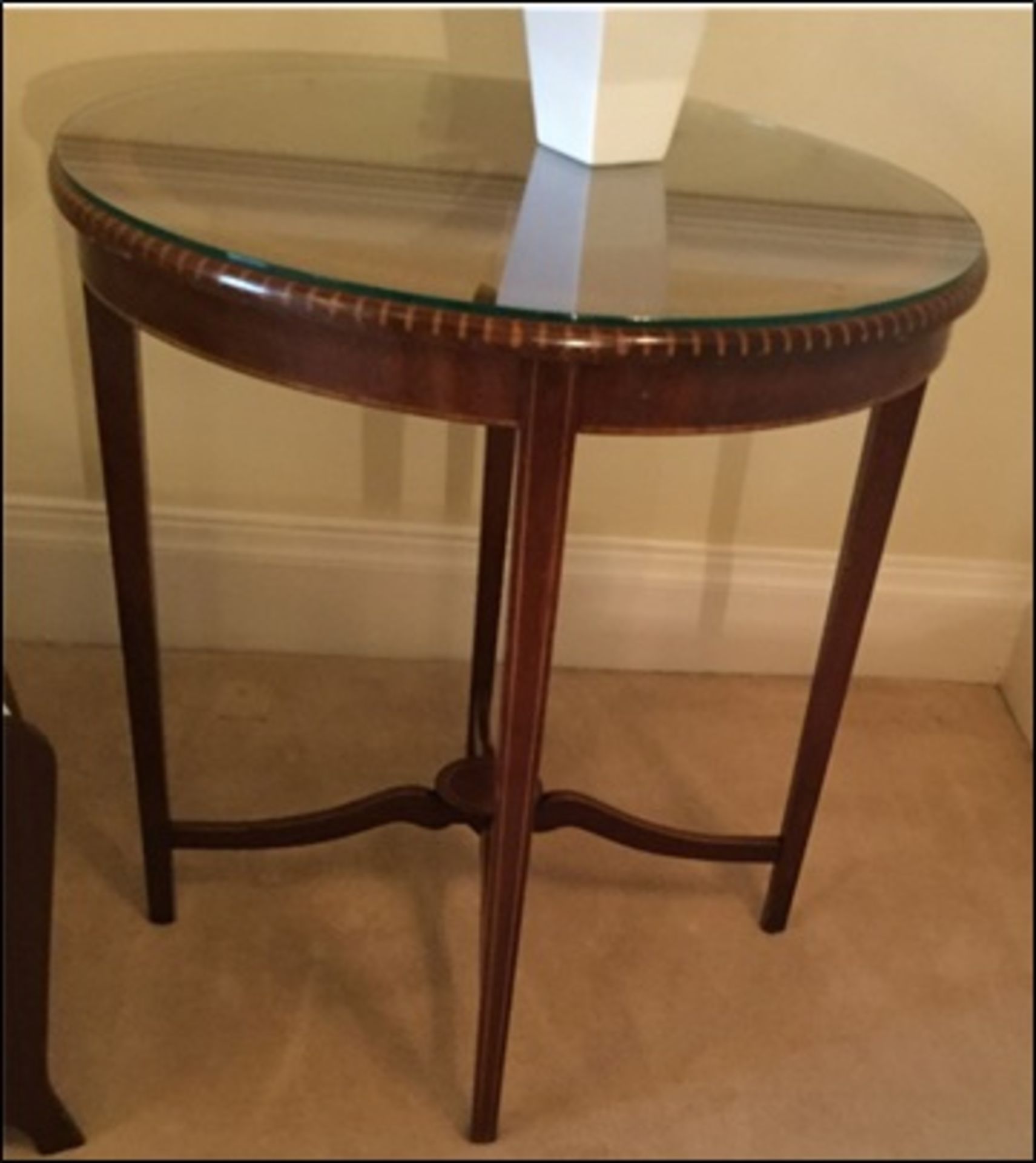 A mahogany pie crust top occasional table with single stretcher on square tapering legs