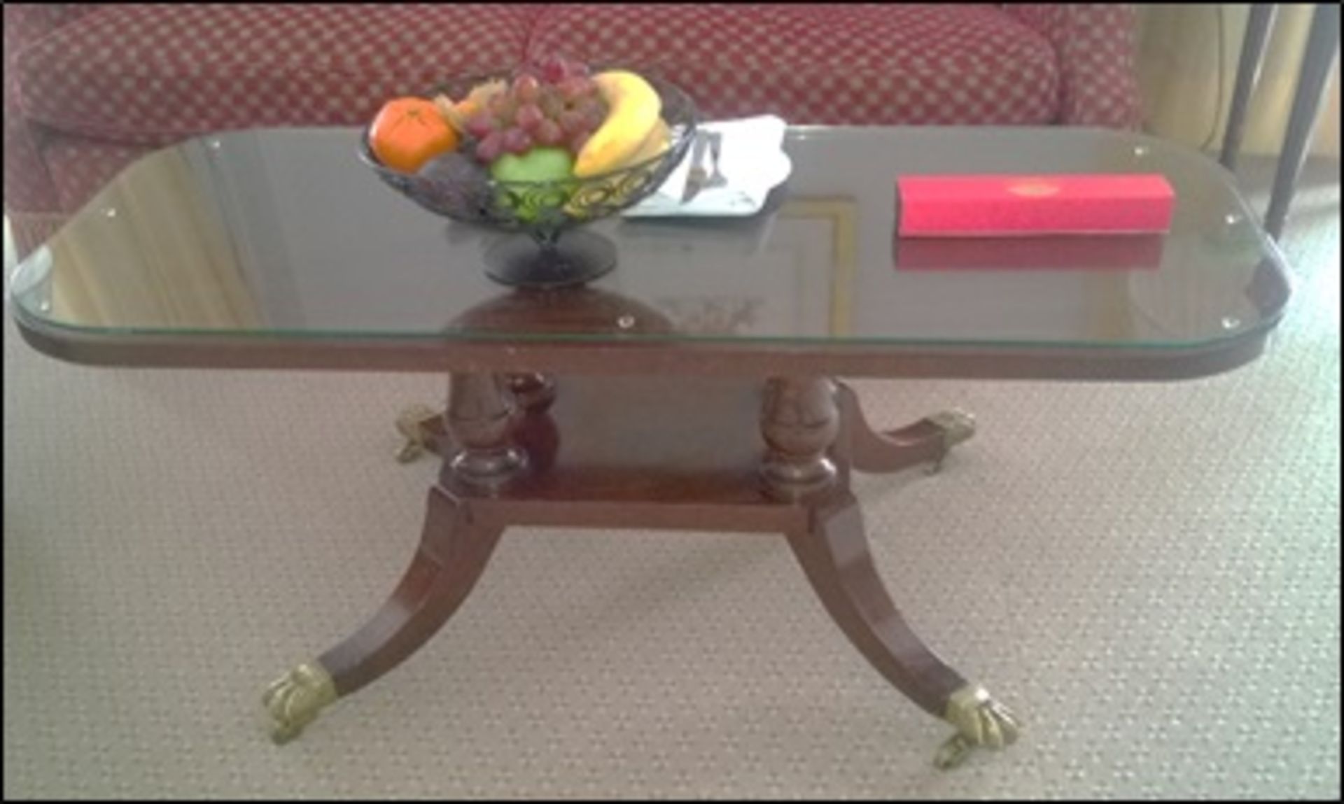 A Georgian style mahogany coffee table the rounded rectangular top above a turned column stretcher