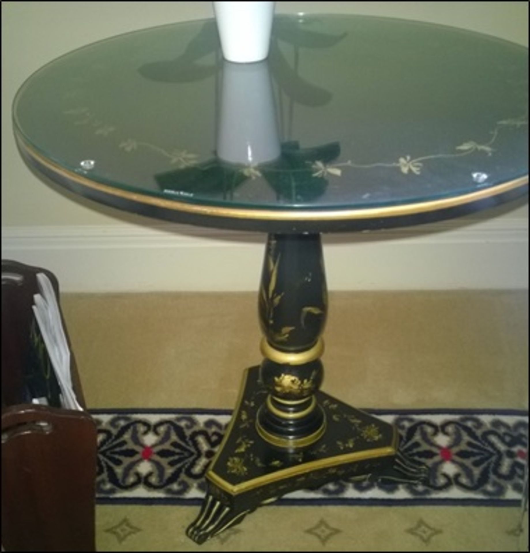 A japanned circular top occasional table on turned column pedestal mounted on triform base