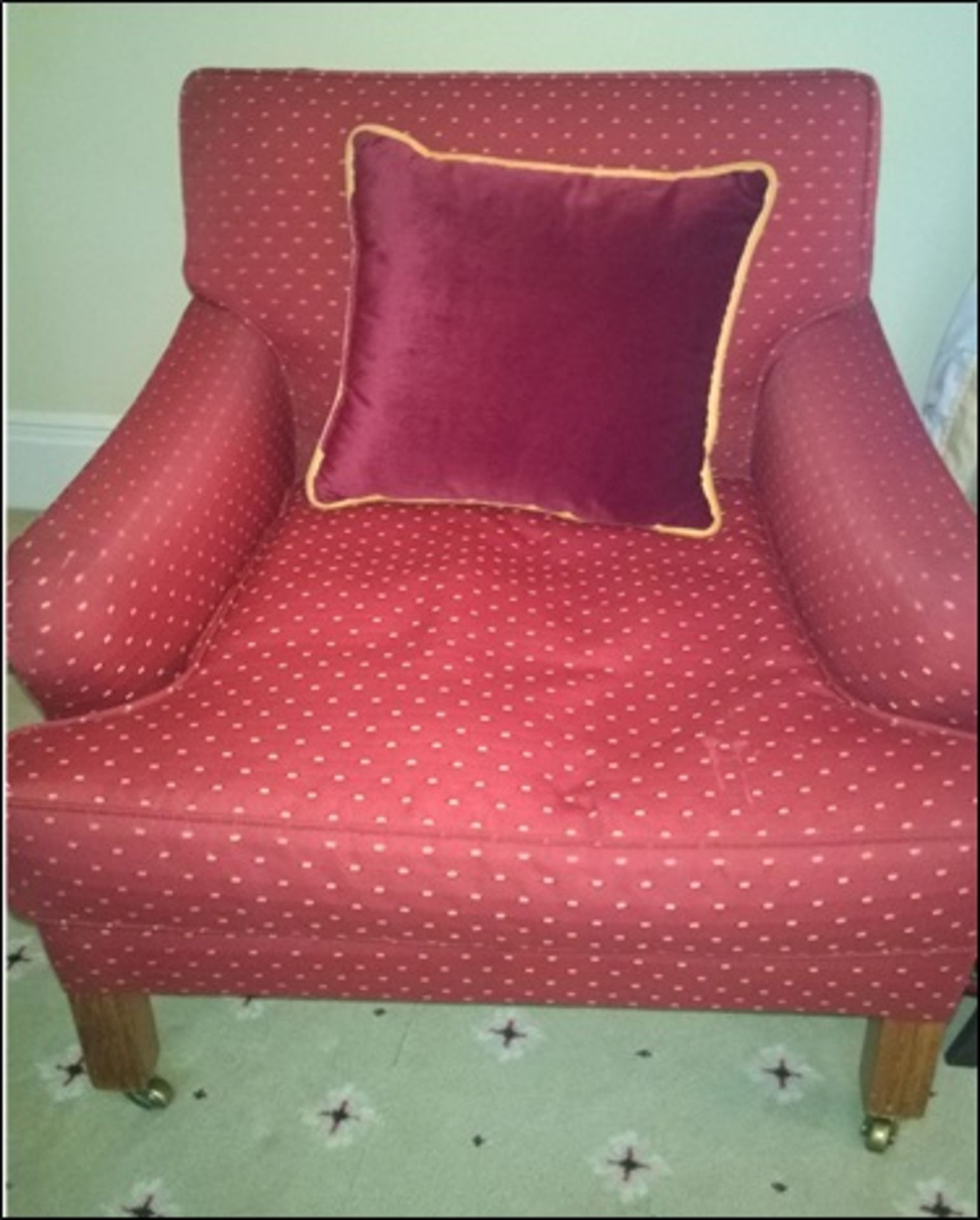 A pair classic upholstered armchair on dark hardwood frame with repeating pattern mounted on front