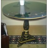 A japanned circular top occasional table on turned column pedestal mounted on tri-form base