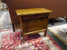 An Arts and Crafts oak occasional table with overhanging top above a frieze drawer and a drop down