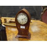 An early 20th century inlaid mahogany mantle clock, the shaped lancet case with stylised foliate and