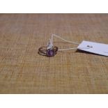 An Edwardian 9ct gold amethyst single stone ring, the round cut stone millegrain set between split