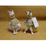 A pair of Gebruder Heubach bisque "Easter" figures, boy and girl, each in original clothes, bunny