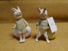 A pair of Gebruder Heubach bisque "Easter" figures, boy and girl, each in original clothes, bunny