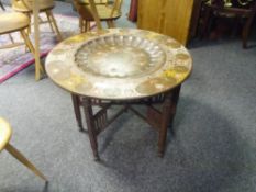 An Indian enamelled brass tray table, early 20th century, the circular tray decorated with