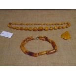 A group of amber or faux amber beads comprising: a single graduated strand of oval beads; a carved