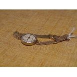 A vintage lady's diamond-set gold wristwatch, the circular white dial with Arabic numerals and