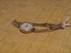 A vintage lady's diamond-set gold wristwatch, the circular white dial with Arabic numerals and