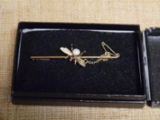 An Edwardian 9ct gold bug bar brooch, the insect set with a seed pearl and small ruby, with safety