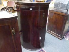 A George III bowfronted chevron string inlaid hanging corner cupboard, with a pair of doors