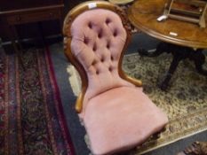 A Victorian walnut-framed nursing chair, the ribbon and scroll carved buttoned back above a stuffed