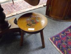 An oak three-legged stool, c. 1900, the seat painted with an armorial and motto.