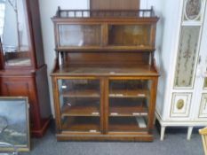 A late 19th century pitch pine glazed "estate" cupboard, the upper section with spindle carved