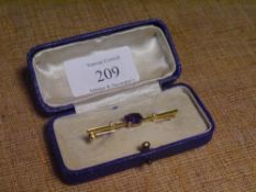 An 18ct gold amethyst and diamond-set bar brooch, the oval-cut amethyst flanked by a pair of