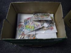 Box containing 1000's of world stamps in packets, a few album pages and some British first day