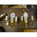 Pair of gilt-metal mounted porcelain twin-light wall sconces, each with floral spray surmount over a