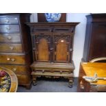 19th century oak, part-ebonised cabinet on stand in the Flemish taste, the upper section with a pair