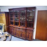 George III style mahogany breakfront bookcase, with fretwork carved frieze above astragal glazed