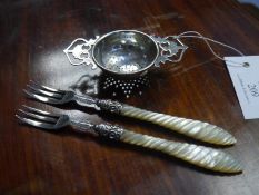 Silver tea strainer, Birmingham 1956, with pierced handles; together with a pair of mother of