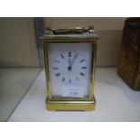 Early 20th century gilt-brass carriage clock, the white enamel dial with Roman numerals, with key.