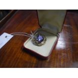 9ct gold amethyst brooch, the circular-cut stone within an open scroll mount.