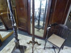 An early 20th century floor lamp with reeded upright on a tripod base