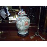A Chinese porcelain baluster jar and cover in the famille rose palette decorated with figures