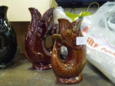 Two Dartmouth fish glug jugs, large and small, brown glazed