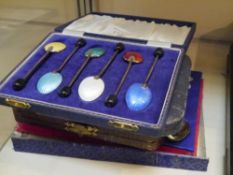 A cased set of six silver coffee bean spoons, together with a cased set of six multi coloured enamel