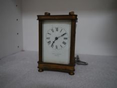 A brass carriage clock, c. 1900, the white enamel dial with Roman numerals, signed Mackay &