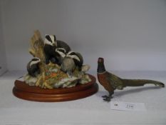 A cold-painted metal model of a standing pheasant; together with a Border Fine Arts badger group "